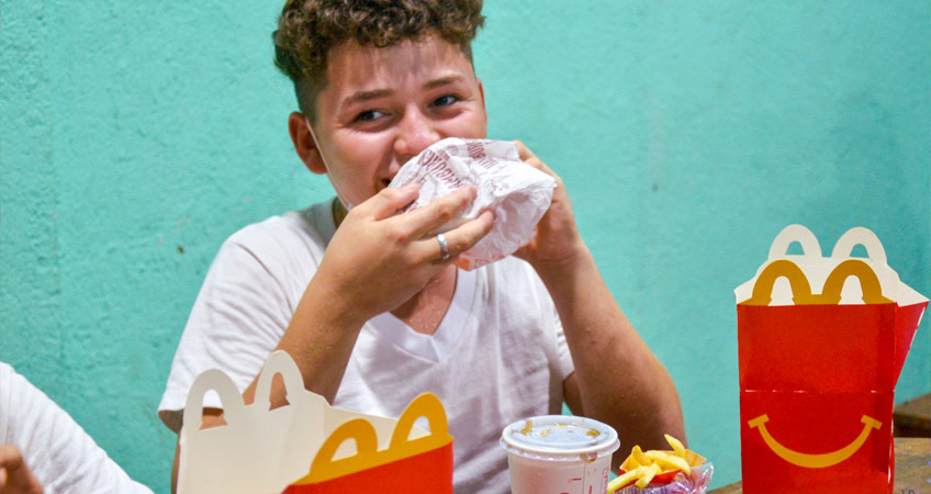 Niño disfruta de Cajita Feliz donada por McDonald's Nicaragua.