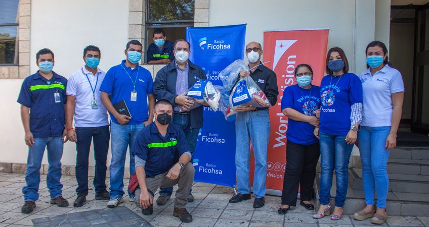 Representantes y colaboradores de Ficohsa durante la entrega de los paquetes alimenticios.